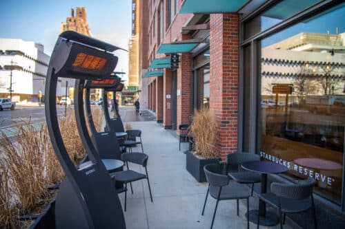 Multiple Bromic heaters lining outdoor coffee shop seating