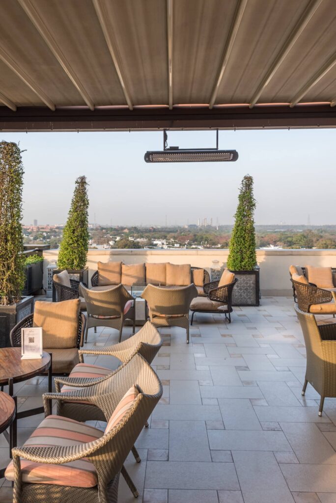 Outdoor eating area with electric heater and views of Delhi on the Horizon